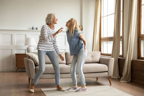 Alegre maduro madre y adulto hija danza en casa — Foto de Stock