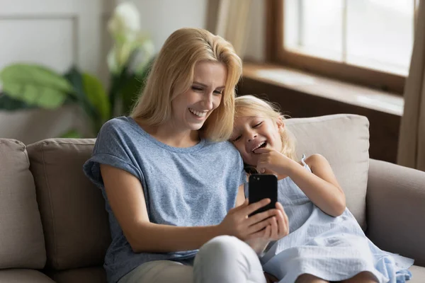 Щаслива молода мама і маленька донька використовують мобільний телефон — стокове фото