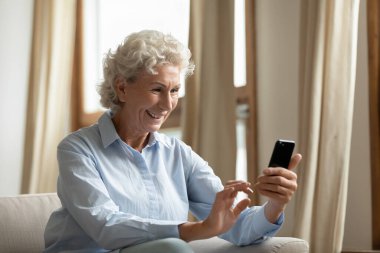 Gülümseyen 60 'lı yılların kadınları cep telefonundan video görüşmesi yapıyor.