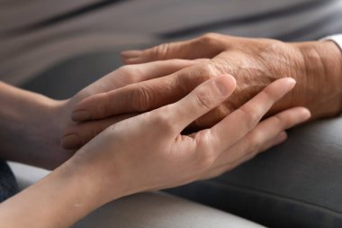 Yetişkin anne ve kızının el ele tutuşması.