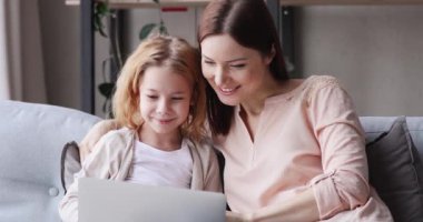 Excited mother and daughter looking at laptop screen feeling winners