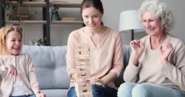 Happy three generations women having fun playing jenga game together
