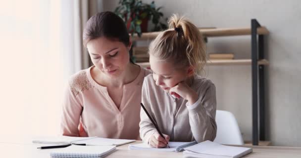 Милый маленький ребенок дочь учится писать с молодой мамой — стоковое видео