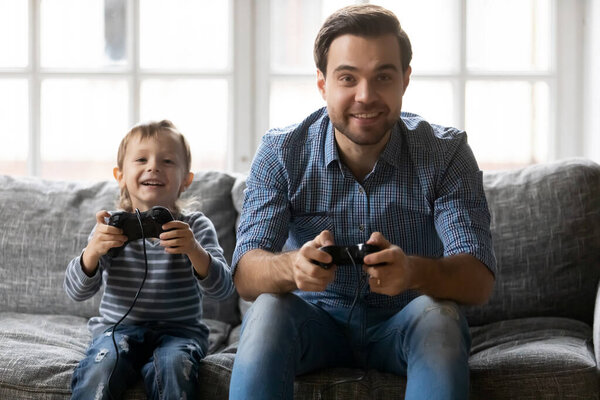 Веселый маленький сын играет с отцом
.