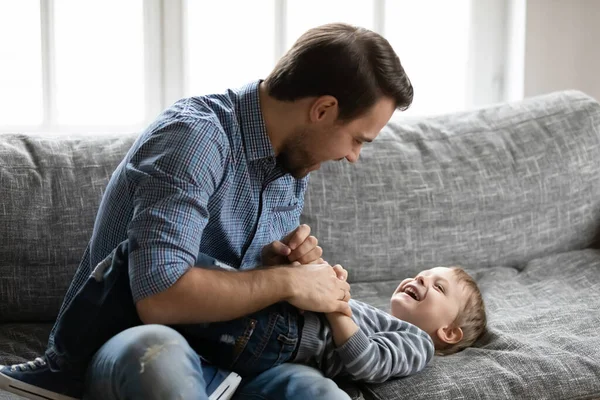 Šťastný mladý otec lechtání malý smích syn — Stock fotografie