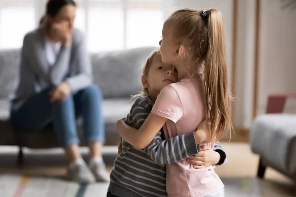 Empática hermana mayor abrazo reconfortante hermanito después de pelea familiar . —  Fotos de Stock