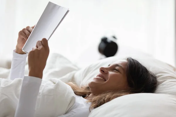 Happy girl relax in bed reading interesting book — Stock Photo, Image