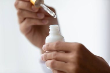 Kadın yüzünü nemlendirmek için sıvı serum kullanıyor.