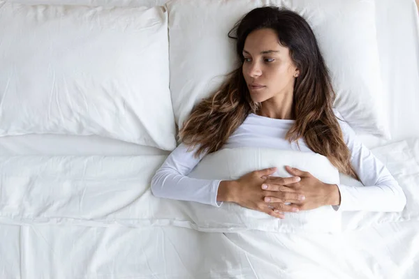 Pensive mladá žena ležící sama v posteli myšlení — Stock fotografie