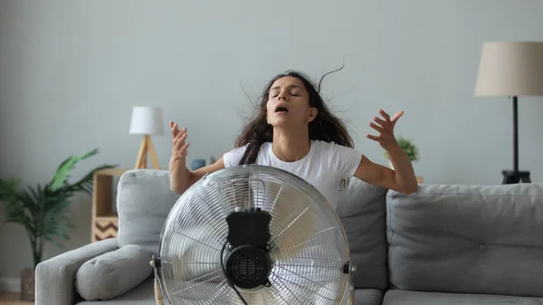 Junge Frau atmet frische Luft aus Ventilator — Stockfoto