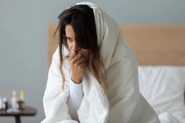 Больной девушке, завернутой в одеяло, плохо. — стоковое фото