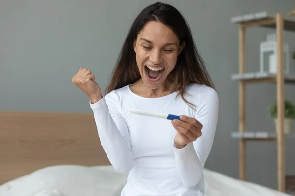 Šťastná mladá žena cítí radost s pozitivním výsledkem těhotenského testu — Stock fotografie