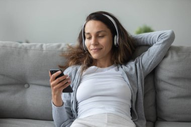 Kulaklıklı milenyum kızı akıllı telefondan müziğin tadını çıkarıyor.