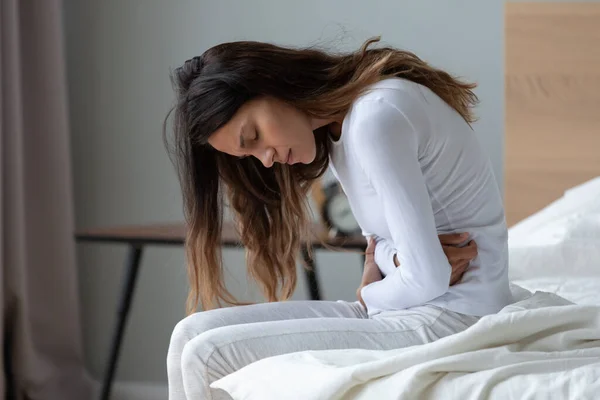 Sick millennial girl suffer from stomach ache at home — Stock Photo, Image