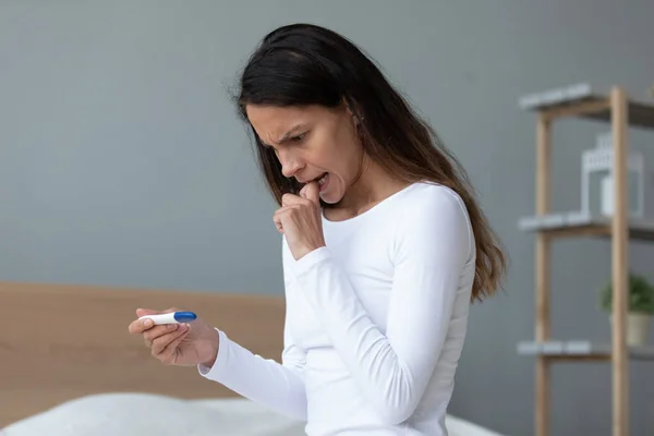 Ansiosa giovane donna guardare i risultati del test di gravidanza di controllo — Foto Stock