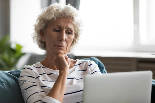 Reifen 50s Großmutter entspannen gerade Film auf Laptop — Stockfoto