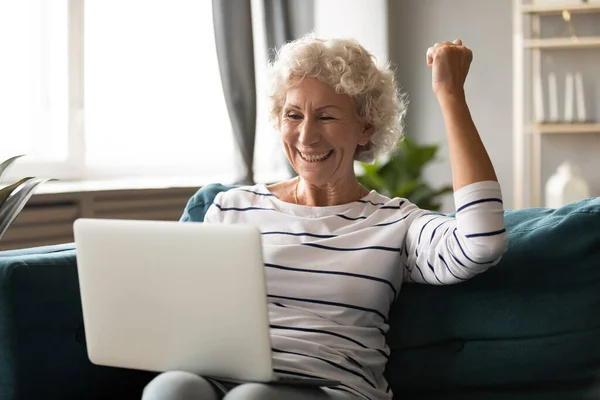 Emocionado mujer madura relajarse con el ordenador portátil leer noticias increíbles — Foto de Stock
