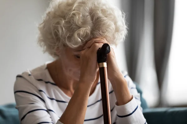 Upset mature woman with cane feel lonely at home