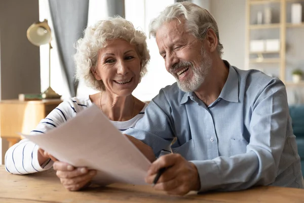 Happy mature couple glad with document health insurance contract — Stock Photo, Image