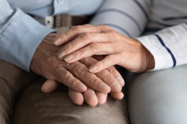 Yaşlı çiftin yakın çekim sevgi gösteren el ele tutuşuyor