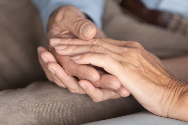 Primer plano de la pareja de ancianos cariñosos cogidos de la mano mostrar cuidado — Foto de Stock