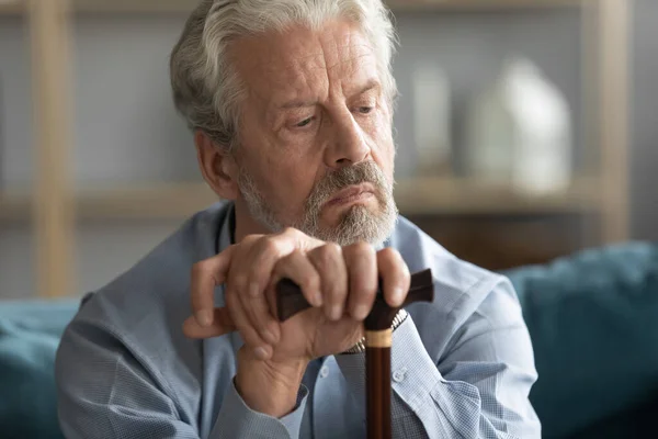 Viejo pensativo con bastón perdido en pensamientos sintiéndose solo — Foto de Stock