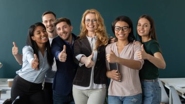 Çeşitli çok ırklı çalışanlar tavsiye kursunda başparmağını kaldırdı