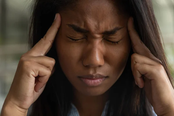 Mujer birracial enferma sufre de migraña en el trabajo — Foto de Stock