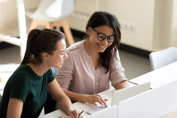 Multiracial female colleagues cooperate working at laptop — Stock Photo, Image