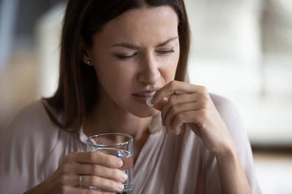 Testa girato da vicino malsana giovane donna che prende antidolorifico . — Foto Stock