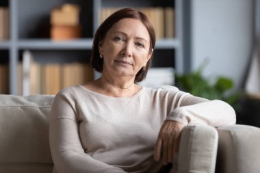 Huzurlu orta yaşlı kadın evdeki rahat koltukta dinleniyor..