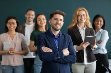 Erkek patronla poz veren çeşitli çalışanların grup fotoğrafı.