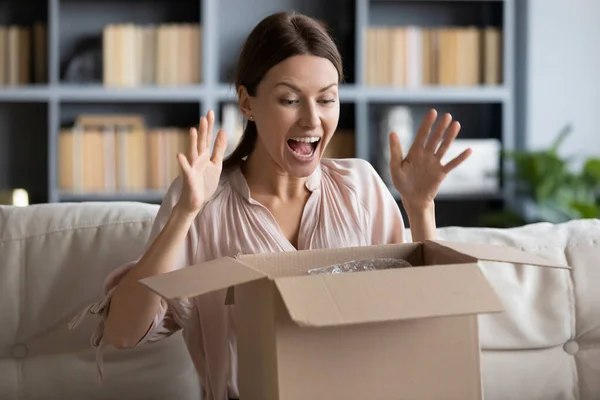 Happy young female client excited by unpacking wished item. — Stock Photo, Image