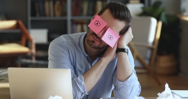 Trabalhador engraçado cochilando no local de trabalho cobrindo os olhos com notas pegajosas — Vídeo de Stock