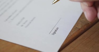 Businessman putting written signature on business paper, close up view