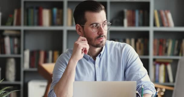 Thoughtful business man thinking of problem solution working on laptop — Stockvideo