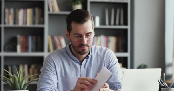 Angry stressed businessman opening envelope reading bad news in letter — Stock video