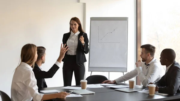 Junger männlicher Manager hebt die Hand, um dem Redner Fragen zu stellen. — Stockfoto