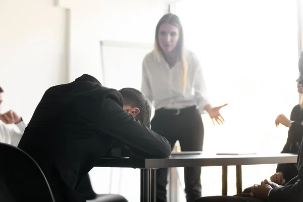 Angry disappointed female team leader boss looking at tired employee. — Stock Photo, Image