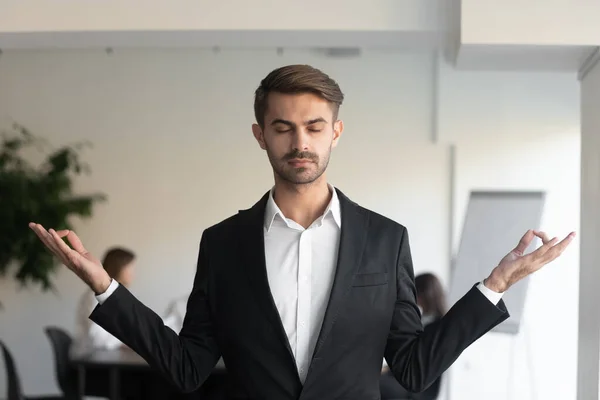 Jeune homme d'affaires conscient faisant des exercices de respiration de yoga . — Photo