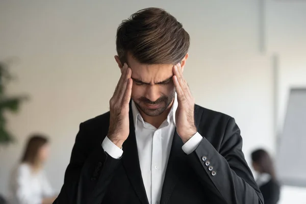 Gestresste Millennials überwältigen an Migräne leidenden Geschäftsmann. — Stockfoto