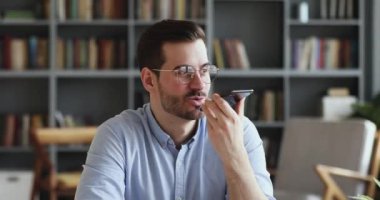 Businessman recording voice message using virtual assistant on smartphone