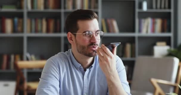 Homme d'affaires enregistrant un message vocal à l'aide d'un assistant virtuel sur smartphone — Video