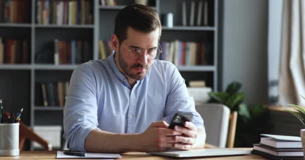 Безумный несчастный бизнесмен чувствует себя раздраженным, используя смартфон в офисе — стоковое видео