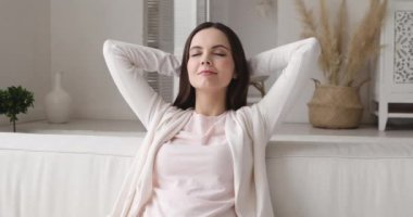 Sakin genç bayan oturma odasındaki rahat koltukta dinleniyor.