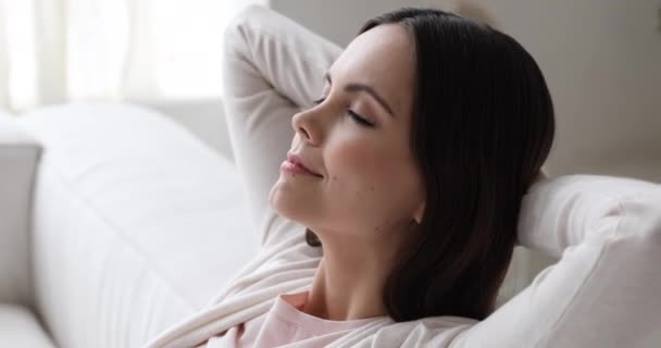 Молода жінка розслабляється на дивані дихає повітрям, крупним планом — стокове відео