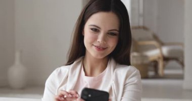 Happy girl looking at smartphone trying new makeup using app
