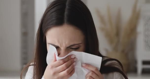 Ill allergic young woman sneezing in tissue blowing running nose — Stock video