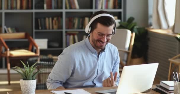 Funny happy businessman wears wireless headphones having fun listening music — Stockvideo