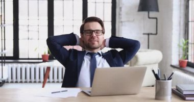 Successful businessman relaxing satisfied with work well done at workplace